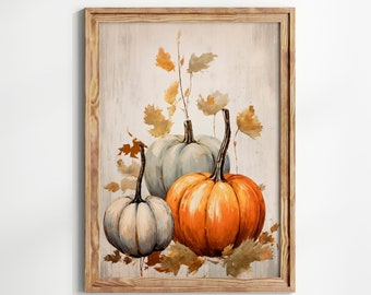 May include: Watercolor painting of three pumpkins in a wooden frame. The pumpkins are white, orange, and light gray, with brown stems and autumn leaves. The background is a light wood grain.