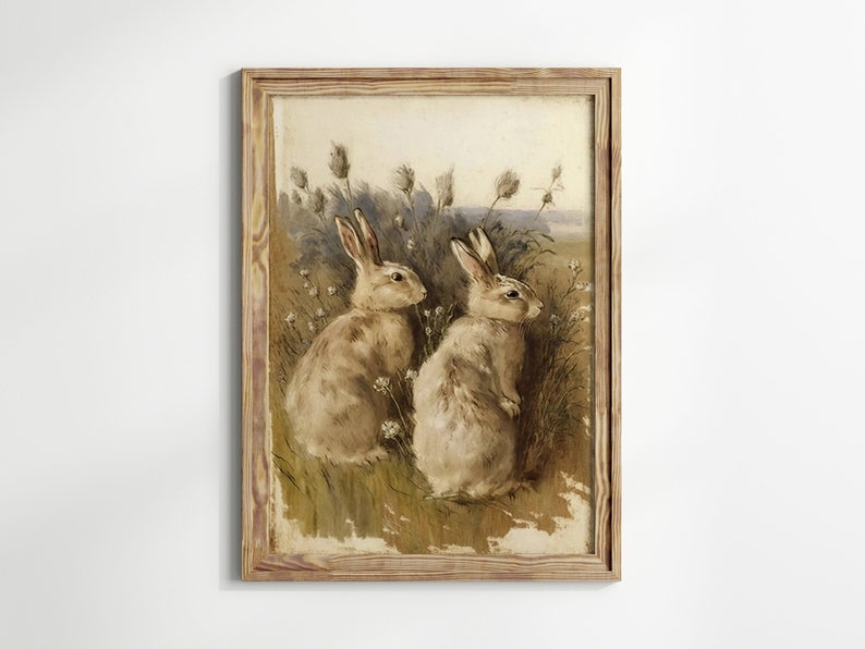 May include: A framed painting depicting two brown rabbits sitting in a field of tall grass and wildflowers. The rabbits are looking at each other.
