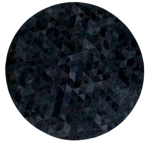 Op de afbeelding: Een ronde, donkergekleurde vloerkleed met een geometrisch patroon van driehoeken. Het ontwerp van het vloerkleed heeft een mozaïek van donkerblauw en zwart, waardoor een textuur ontstaat. Het vloerkleed is cirkelvormig en tegen een witte achtergrond geplaatst.