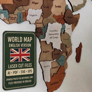 May include: A multi-coloured wooden world map wall art piece featuring laser-cut country shapes in various wood tones. A rectangular green sign is included with the text: WORLD MAP ENGLISH VERSION, the UK flag, and LASER CUT FILES AI PDF SVG EPS.