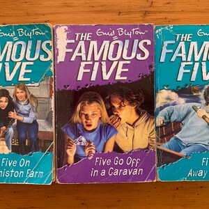 May include: Three paperback books with blue, purple, and turquoise covers. The books are part of the "Famous Five" series by Enid Blyton. The titles are "Five On Finniston Farm", "Five Go Off in a Caravan", and "Five Run Away Together".