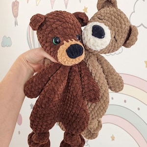 Könnte beinhalten: Zwei handgefertigte Häkelteddybären in Brauntönen. Einer ist dunkelbraun mit grünen Augen und einer beigen Schnauze, der andere ist hellbraun. Die Bären sind weich und kuschelig, perfekt für ein Kinderzimmer oder einen Kindergarten.