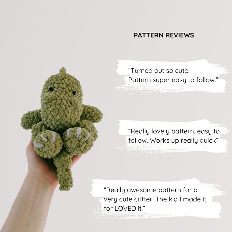 May include: A green crocheted dinosaur toy with grey claws. The toy is being held by a hand. The image includes text that reads "PATTERN REVIEWS" and customer reviews of the pattern.