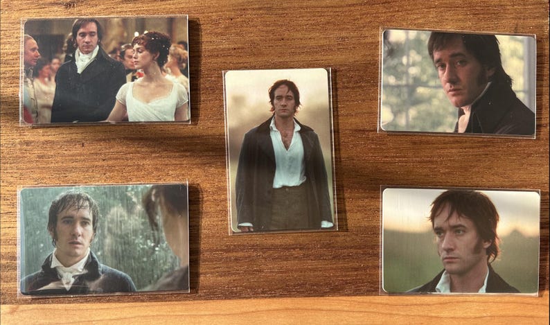 Puede incluir: Un conjunto de cinco imanes rectangulares con im&aacute;genes de actores con trajes de &eacute;poca, sobre un fondo de madera. Los imanes muestran escenas de un drama hist&oacute;rico, con retratos de personajes.