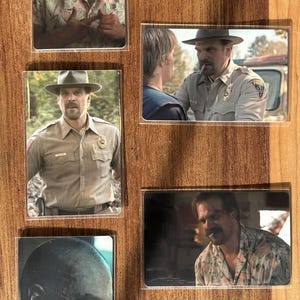 Puede incluir: Una colecci&oacute;n de tarjetas fotogr&aacute;ficas rectangulares que muestran a un hombre con bigote en varias escenas. Las im&aacute;genes muestran al hombre con una camisa hawaiana, un uniforme de polic&iacute;a y un sombrero. Las tarjetas est&aacute;n dispuestas sobre una superficie de madera.