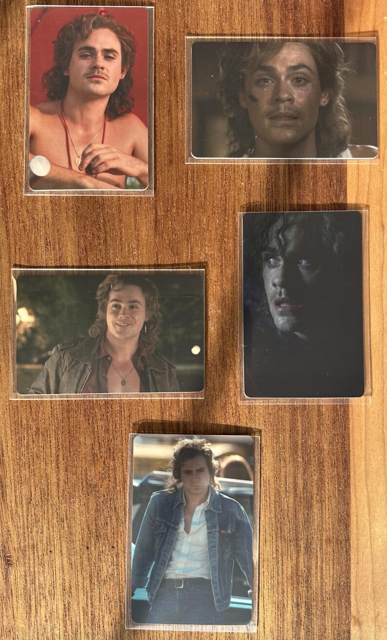 Puede incluir: Juego de cinco cromos con un hombre de pelo largo y ondulado. Los cromos muestran diferentes im&aacute;genes del hombre, incluyendo una con fondo rojo y otra con chaqueta vaquera. Los cromos est&aacute;n en fundas protectoras.