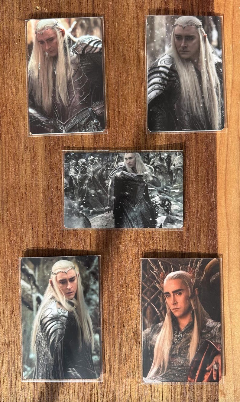 Puede incluir: Conjunto de cinco cromos que representan a un personaje con pelo largo y rubio y rasgos &eacute;lficos. Los cromos muestran al personaje en diferentes escenas, vistiendo armadura y ropa regia. El fondo es una superficie de madera.