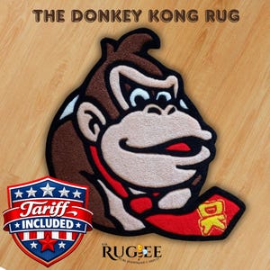 May include: A Donkey Kong rug featuring the character's face, with brown, tan, red, and white colors. The rug has a red border and a red DK logo. The text "THE DONKEY KONG RUG" is at the top. The rug is on a wood-grain surface.