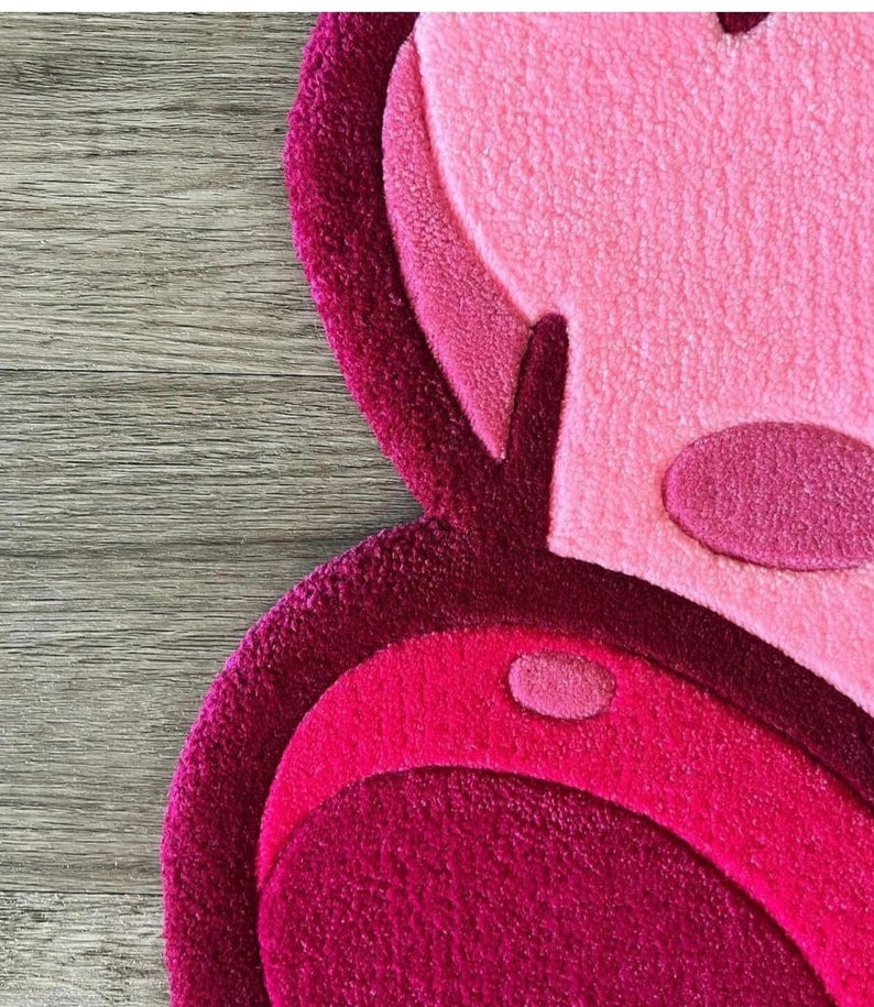 Puede incluir: Una alfombra de felpa rosa y roja con un dise&ntilde;o circular. La alfombra est&aacute; hecha de un material suave y peludo y tiene un patr&oacute;n abstracto &uacute;nico.