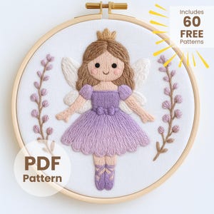 Puede incluir: Arte de aro de hadas bordado con una princesa con corona, alas y un vestido morado. El diseño incluye detalles florales y el texto "PDF Pattern" y "Includes 60 FREE Patterns". El bordado está en un aro de madera.