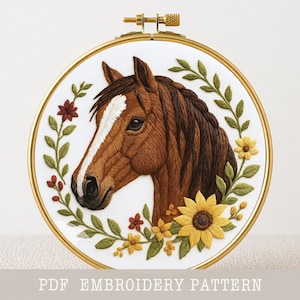 Peut inclure: Broderie d'une tête de cheval dans un cercle doré. Le cheval est brun avec une raie blanche sur le visage. La broderie est entourée de feuilles vertes, de tournesols jaunes et de fleurs rouges. Le texte "PDF EMBROIDERY PATTERN" est en bas.