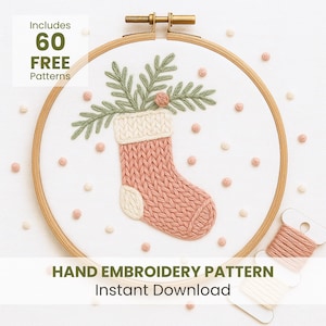 Pode incluir: Um padrão de bordado à mão com uma meia de Natal rosa e branca, adornada com folhagem verde, dentro de um bastidor de madeira. O texto diz "Includes 60 FREE Patterns" e "Hand Embroidery Pattern Instant Download". Inclui novelos de linha.