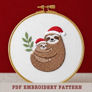 May include: Embroidered hoop art featuring a mother and baby sloth wearing Santa hats, hugging each other. The sloths are brown with white accents, and the hats are red with white trim. A green leafy branch is on the left. The text "PDF EMBROIDERY PATTERN" is at the bottom.