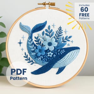 May include: Embroidered whale design in shades of blue, featuring floral and botanical elements, set within a wooden embroidery hoop. The text "PDF Pattern" is visible. The image also includes the text "Includes 60 FREE Patterns".
