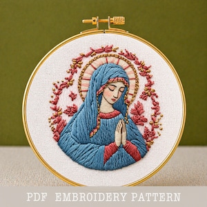 May include: Embroidered artwork of a religious figure in a gold hoop. The figure wears a blue veil and red accents, with a halo and floral wreath. The text "PDF EMBROIDERY PATTERN" is at the bottom.