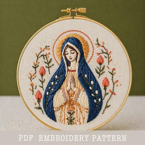 Könnte beinhalten: Gesticktes Stickrahmen-Kunstwerk mit einer religiösen Figur mit blauem Schleier und Heiligenschein, umgeben von floralen Stickereien. Das Design befindet sich auf einem cremefarbenen Stoff, der von einem goldenen Reifen umrahmt wird. Der Text unten lautet "PDF EMBROIDERY PATTERN".