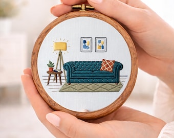 以下が含まれることがあります： ミニチュアのリビングルームのシーンが描かれた、詳細な刺繍枠。デザインには、ティール色のタフテッドソファ、フロアランプ、抽象芸術が含まれています。「PDF EMBROIDERY PATTERN」の文字が下部にあります。