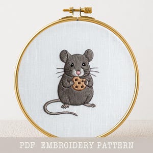 Pode incluir: Design bordado de um rato cinzento segurando um biscoito, em um aro dourado. O rato tem um nariz rosa e bigodes. O texto "PDF EMBROIDERY PATTERN" está na parte inferior.