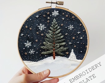 May include: A hand embroidery template featuring a pine tree with a snowy background and a starry night sky. The template is in a round embroidery hoop with a wooden frame.