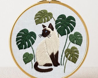 Schema PDF per ricamo di un gatto siamese e una monstera, adatto ai principianti, ideale per amanti delle piante e dei giardini tropicali.