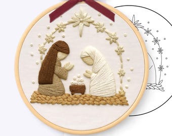 May include: A hand embroidery pattern in an 8 inch wooden hoop featuring a nativity scene with two figures in brown and white robes kneeling before a manger. A dark red velvet ribbon is tied at the top. Text reads HAND EMBROIDERY PATTERN - PDF.