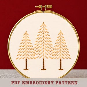 Op de afbeelding: Een crème borduurring met drie geborduurde dennenbomen in bruintinten. De bomen hebben gedetailleerde bladerpatronen en bruine stammen. De tekst "PDF EMBROIDERY PATTERN" staat onderaan.