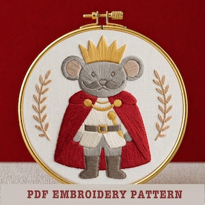 May include: Embroidered hoop art featuring a regal mouse wearing a gold crown and red cape. The mouse is dressed in a white outfit with a gold belt and boots. The text "PDF EMBROIDERY PATTERN" is at the bottom.