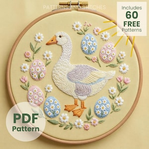 May include: Embroidered hoop art featuring a goose surrounded by floral and egg designs. The goose is white, gray, and tan, with orange feet and beak. The eggs are decorated with flowers. The text "PDF Pattern" is visible.