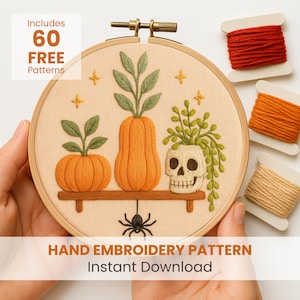 May include: A hand embroidery pattern in a wooden hoop features an orange pumpkin, a tall orange vase, and a skull with green foliage. The design includes a spider and text that reads "Hand Embroidery Pattern Instant Download". Includes 60 free patterns.