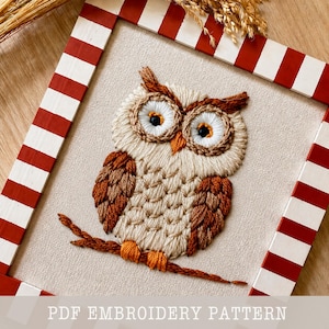 May include: Embroidered owl artwork in a red and white striped frame. The owl is made with beige, brown, and orange thread, sitting on a brown branch. The text "PDF EMBROIDERY PATTERN" is at the bottom.