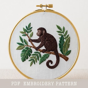 May include: An embroidery hoop featuring a brown monkey perched on a branch, surrounded by green leaves. The monkey is intricately stitched with detailed fur. The text "PDF EMBROIDERY PATTERN" is at the bottom. The hoop has a gold-colored metal frame.
