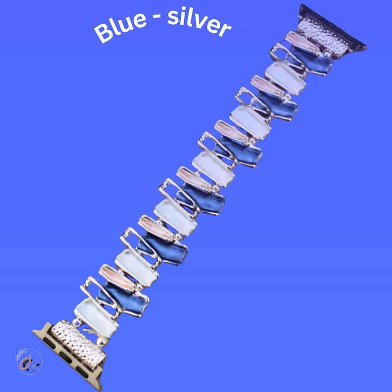 May include: A silver and blue Apple Watch band with a geometric design. The band is made of metal and has a gradient of blue, white, and pink colors.