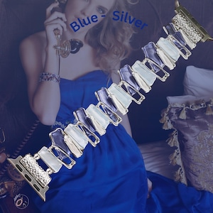 May include: A silver and blue Apple Watch band with a geometric design. The band is made of metal and has a sparkly finish. The text "Blue - Silver" is visible in the image.