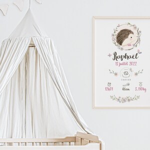 May include: A white framed print with a watercolor illustration of a hedgehog surrounded by flowers. The print includes the name "Rapha&euml;l", the date "13 juillet 2022", the zodiac sign Cancer, and the baby's birth stats: 12h01, 48cm, 3.110kg.