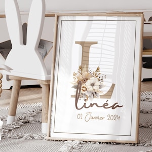 Peut inclure: Une impression encadrée avec une grande lettre L brune décorée d'un arrangement floral dans des tons de brun et de blanc. Le nom "Linéa" est écrit en écriture brune sous la lettre, et la date "01 Janvier 2024" est écrite en écriture brune plus petite sous le nom.
