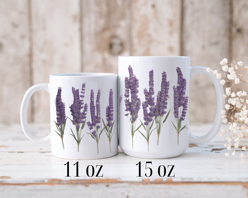 Op de afbeelding: Twee witte keramische mokken met lavendelbloemmotieven. De mok links is 11 ounce en de mok rechts is 15 ounce.