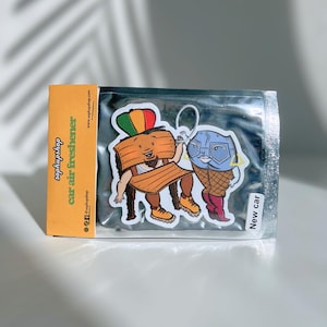 May include: Car air freshener with two cartoon characters: a wooden chair wearing a crown and a blue-faced ice cream cone. The packaging includes the text "bophupshop car air freshener" and "New car".