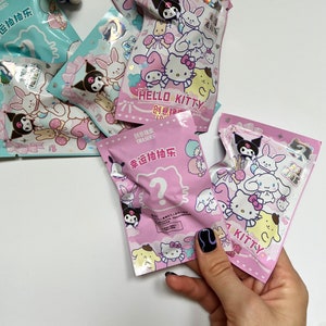 May include: Pink and blue plastic bags featuring Hello Kitty and Kuromi characters. The bags contain erasers and have the text 'Creative Erasers' and 'Lucky Draw' on them.