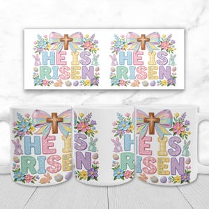 May include: White ceramic mug with the text "HE IS RISEN" in pastel colors, decorated with a cross, flowers, and Easter eggs. The design is repeated on a matching rectangular print.