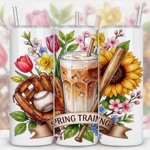 May include: White tumbler with a baseball theme, featuring a baseball glove, baseball, and bat, alongside a refreshing iced coffee. Adorned with spring flowers and the text "SPRING TRAINING" on a banner. A perfect gift for baseball enthusiasts.