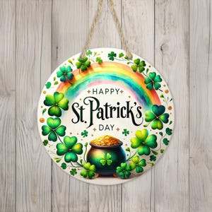 Könnte beinhalten: Ein rundes weißes Schild mit einem grünen Kleeblatt-Rand und einem Regenbogen in der Mitte. Das Schild sagt "Happy St. Patrick's Day".