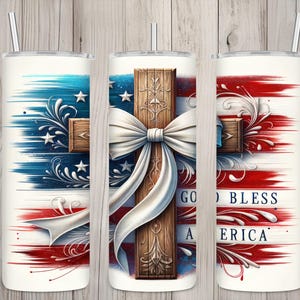 May include: A white tumbler with a red, white, and blue American flag design. A wooden cross with a white bow is centered on the flag. The text "God Bless America" is printed on the tumbler.