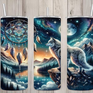 May include: Three insulated tumblers with a nature-themed design. One features a dreamcatcher, the others depict a wolf against a backdrop of mountains, a starry sky, and a full moon. Each tumbler has a silver straw.