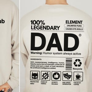以下が含まれることがあります： 前面に「Cool Dads Club」と「No rules, just dad jokes」の文字が入ったサンドカラーのスウェットシャツ。背面には「100% LEGENDARY DAD」と、追加のテキストとグラフィック（「Warning: Humor system always active」など）が描かれています。