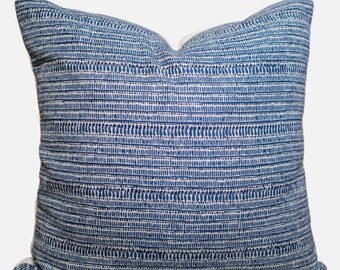 Könnte beinhalten: Ein blaues und weißes Kissen mit einem dezenten geometrischen Muster. Das Kissen ist aus einem weichen, gewebten Stoff gefertigt und hat eine quadratische Form.