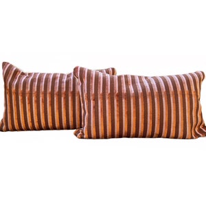 May include: Two brown and pink striped velvet throw pillows with a cream colored border.