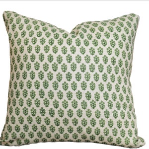 May include: A green and white throw pillow with a floral pattern. The pillow is made of a soft, textured fabric.