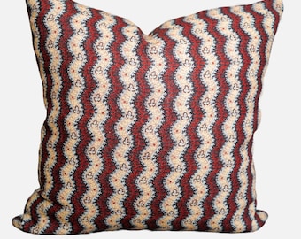 May include: A decorative cushion with a red, white and black wavy pattern. The pattern features small floral designs.