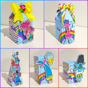 Può includere: Una collezione di scatole regalo colorate a tema Trolls. Le scatole sono azzurre con accenti arcobaleno e presentano vari personaggi dei Trolls. Alcune scatole hanno fiocchi gialli e pompon. La parola "Trolls" è stampata.