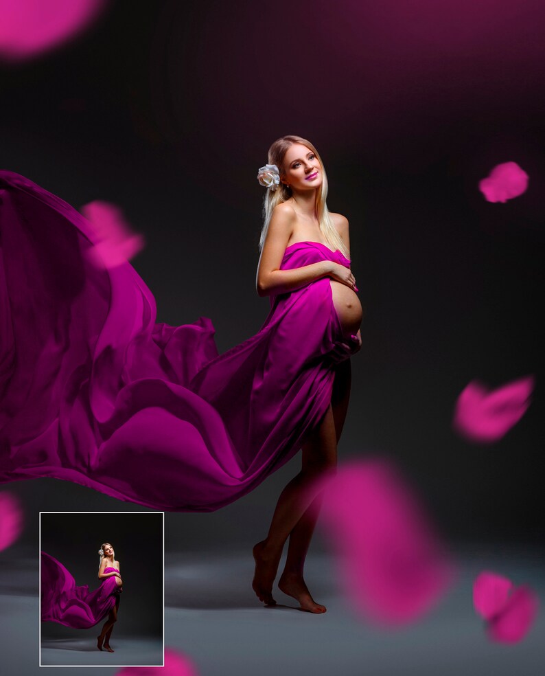 May include: A pregnant person stands draped in a flowing magenta fabric, with a white flower in their hair. The fabric billows around them, and magenta petals float in the air against a dark background. A small inset image is in the lower left corner.